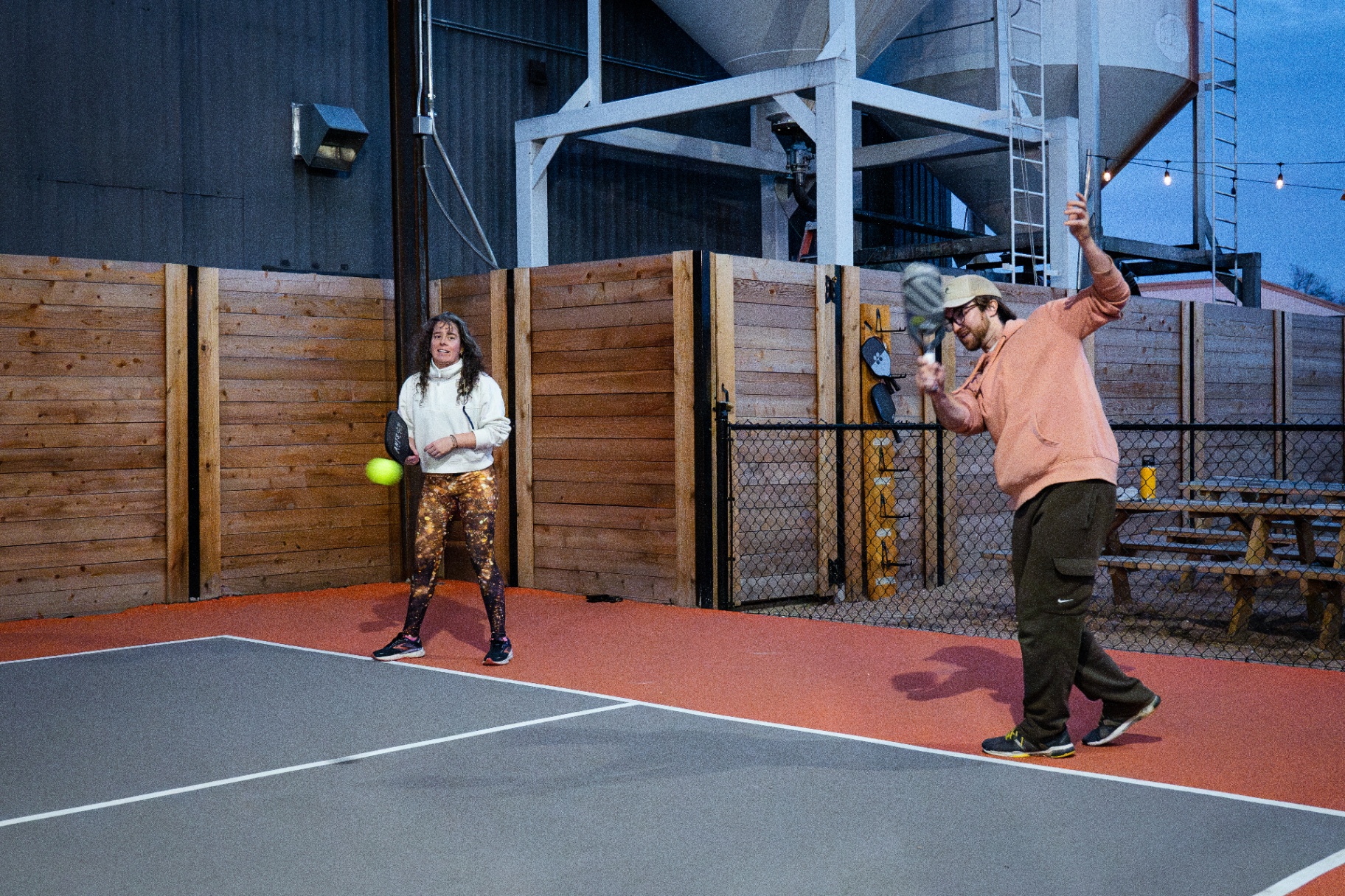 Rally in progress on the outdoor court at blue hour