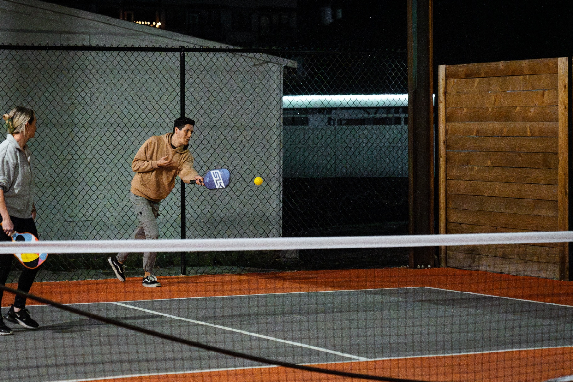 Player serving on the indoor pickleball court at Ants Beer Cave