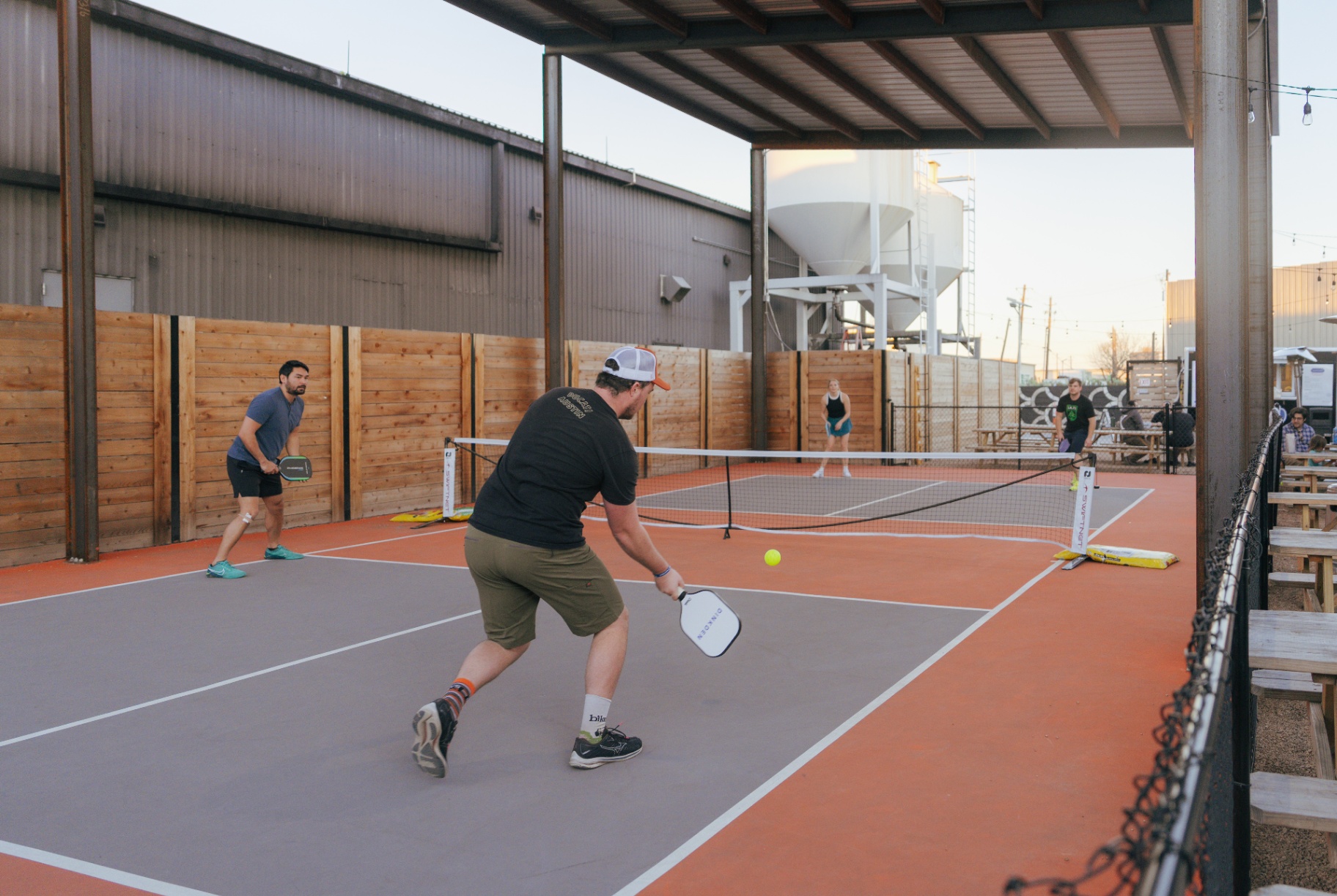 Doubles match on the covered outdoor court at golden hour