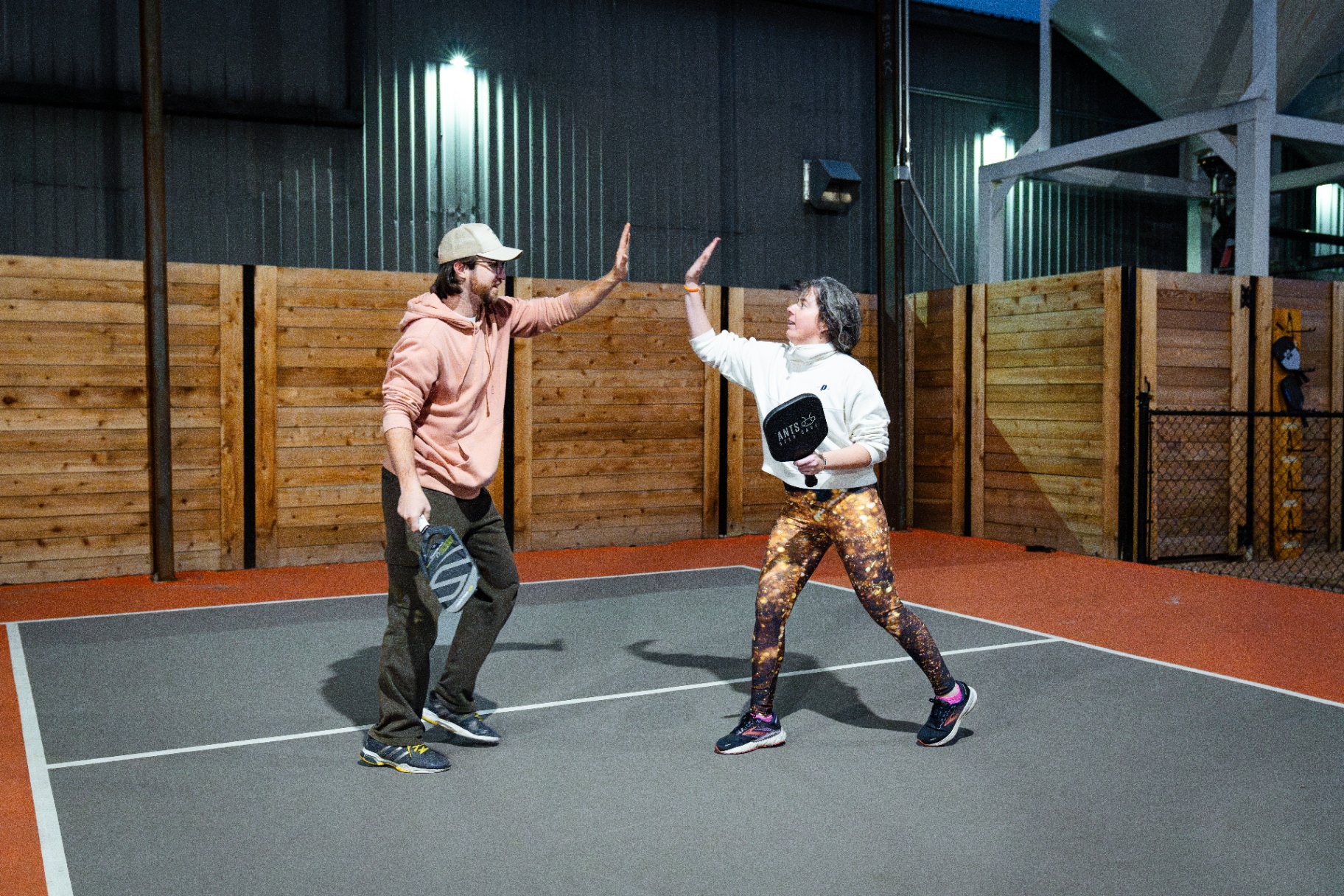 Players high-five with an Ants Beer Cave branded paddle